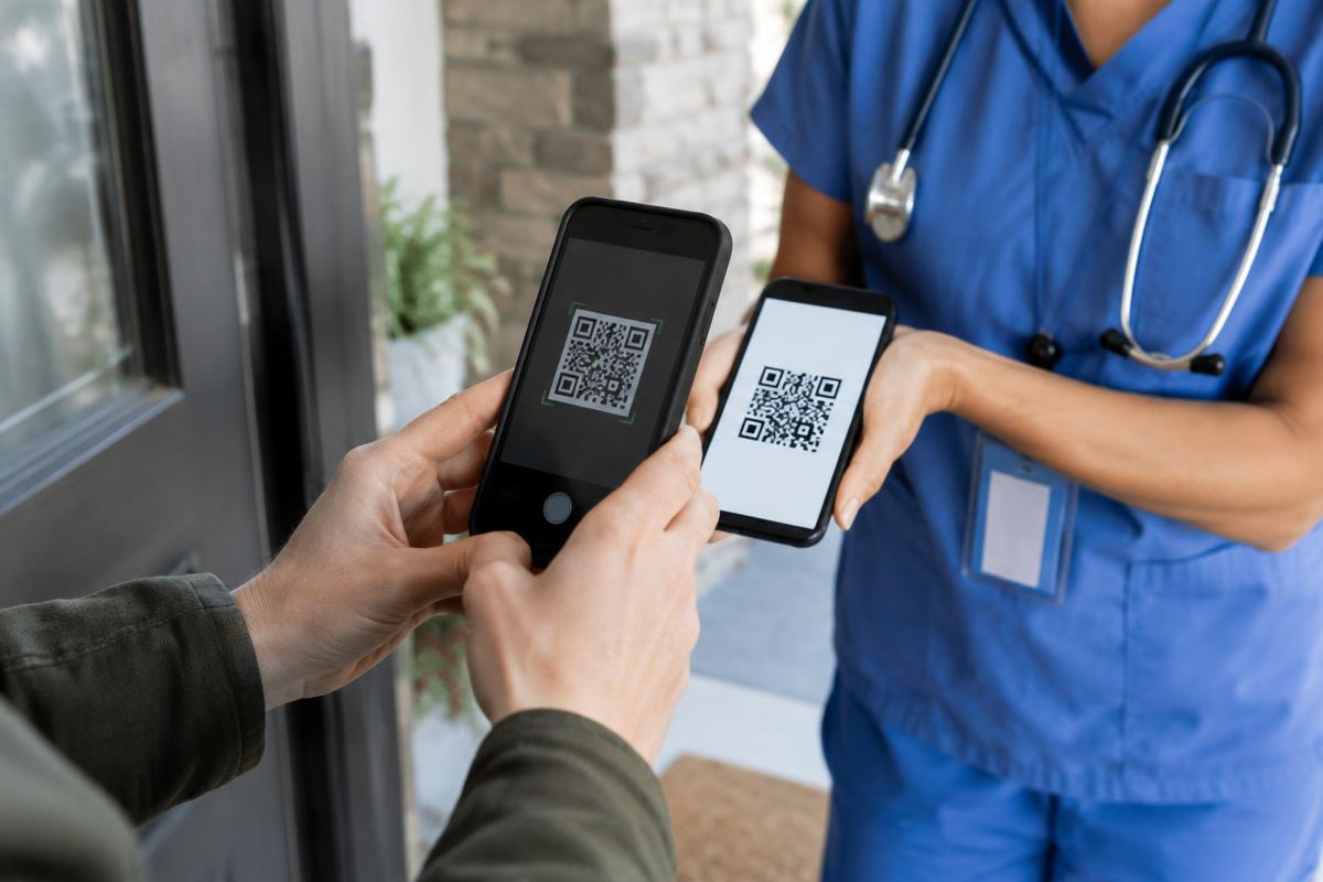 Paciente lendo o QR Code do profissional de saúde na porta de casa